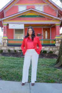 Tonia Wright, President and CEO of Grace Advertising & Consulting and Altruism Media, posing in front of a colorful house.
