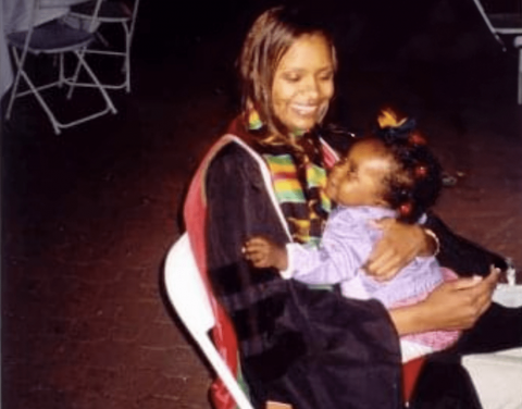 Tiana Ford as a child sitting in her mother's lap at her medical school graduation.